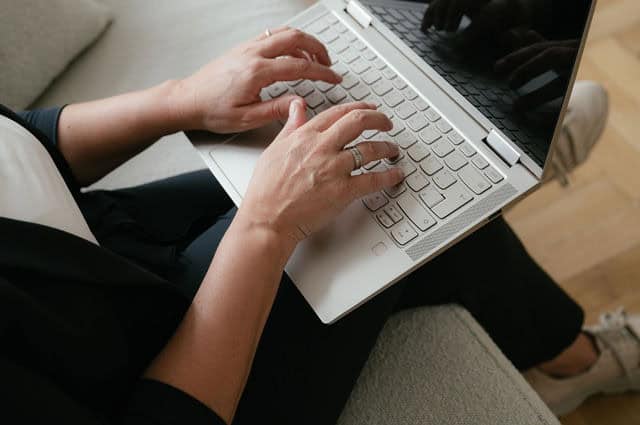 Daniela Reisner am Laptop. Zu sehen sind die Finger, wie sie auf der Tastatur tippen.